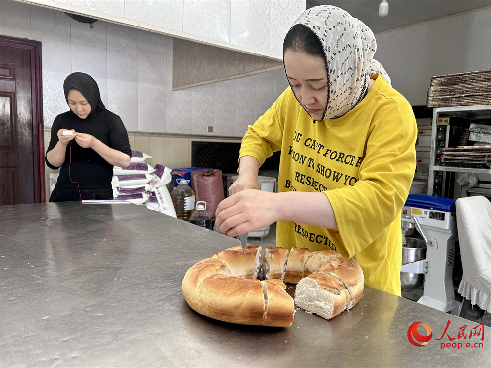 饃饃店老板切割黃南饃饃。人民網(wǎng)記者 陳明菊攝